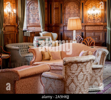 Gemütliches Wohnzimmer mit rosa Sofa und hölzerne Wände Stockfoto