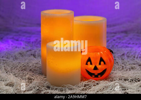 Halloween Urlaub noch Leben von einem gelben elektrischen Kerzen und einen kleinen jack o lantern Kürbis Stockfoto