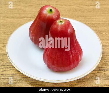 Frische rote reife Wasser Äpfel, Rose Äpfel, Wasser Guave oder Jambu Air auf einem weißen Teller. Stockfoto