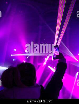 Syon Park, London, Großbritannien, 15. November 2019. Eine junge Frau nimmt Schnappschüsse von den fantastischen Lasershow im Inneren der großen Wintergarten. Illuminationen Der verzauberte Wald" im Syon Park und rund um den historischen Syon House wieder öffnet für die Öffentlichkeit mit einer Spur der schön beleuchteten Szenen rund um den Park und das historische Syon House mit seiner großen Wintergarten und Lasershow im Inneren. Verzauberte Wälder wird geöffnet, freitags, sonntags 15. Nov, 1. Dez, 2019. Credit: Imageplotter/Alamy leben Nachrichten Stockfoto