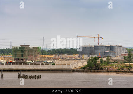 Lange Tau Fluss, Vietnam - 12. März 2019: Phuoc Khanh. Industrielle Anlagen im Bau zeigt Office Block und Silos mit gelben Kran unter l Stockfoto