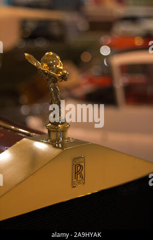 Vorn schließen Sie herauf, Rolls Royce geflügelte Frau Kühlerfigur, RR Logo auf Messing Grill und roten schwenkbaren Haube. Stockfoto