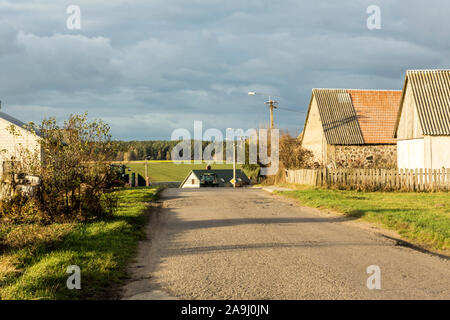 Ende Herbst. Blick auf die Dorfstraße. Wohnhäuser, Scheunen, Ausrüstung. Der Wald im Hintergrund. Podlachien. Polen. Stockfoto