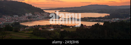 Serene Dämmerung Panorama der mittelalterlichen Fischerdorf Pontedeume mit seinen Eisen und Stein Brücke orange sky La Coruña Galicien Spanien Stockfoto