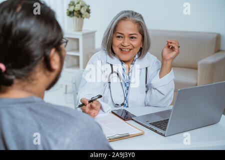 Ärzte und Patienten sprechen und schauen sich an Stockfoto