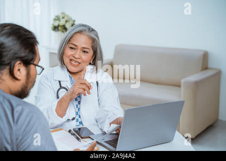 Ärzte und Patienten sprechen und schauen sich an Stockfoto