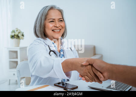 Arzt und Patient, die Hände schütteln Stockfoto