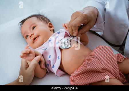 Kleines Baby, während sie von Arzt untersucht Stockfoto