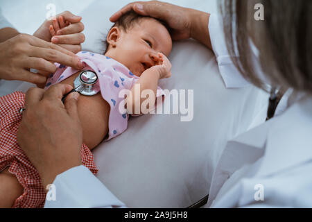 Kleines Baby, während sie von Arzt untersucht Stockfoto