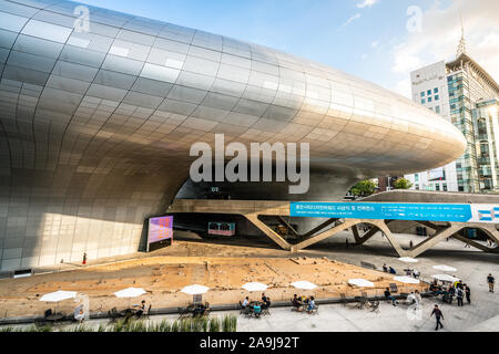 Seoul Korea, 23. September 2019: Dongdaemun Design Plaza oder DDP Gebäude Ansicht mit bleibt der Stadt forttress und die Menschen in einem Café in Seoul Sitzung Stockfoto