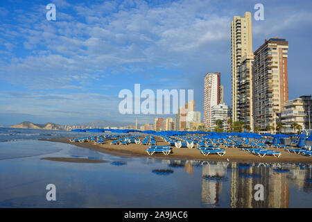 Benidorm, Alicante/Spanien - 20. Oktober 2019: Skyline der Stadt und den Strand Playa Levante, am frühen Morgen mit Reflexionen in feuchten Sand Stockfoto