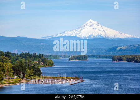 Landschaft mit einem lokalen Marina mit angelegten Yachten und Boote auf dem Columbia River mit Bäumen bewaldeten Inseln und die schneebedeckten Berge Mount Hood auf backgrou Stockfoto