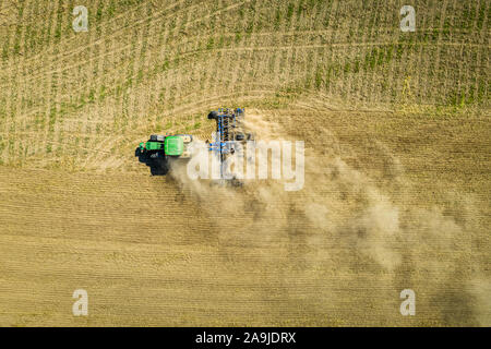 Top down Sicht der Traktor pflügen trockenen Feld, Luftaufnahme Stockfoto