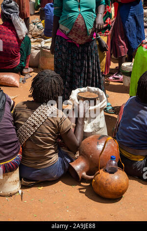 Äthiopien, South Omo, Key Afer, Markt am Donnerstag, Banna Tribal Frau Verkauf von Sorghum Getreide Stockfoto