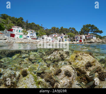 Mediterrane Häuser der Fischer mit Booten auf felsigen Strand und Schule der Fische unter Wasser Meer, Spanien, Costa Brava, Palamos, Katalonien, geteilte Ansicht Stockfoto