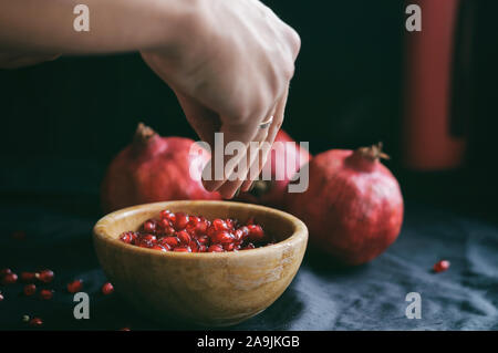 Mädchen reinigt die Frisch rot saftige Granatapfel in der Frame nur weibliche Hände Stockfoto