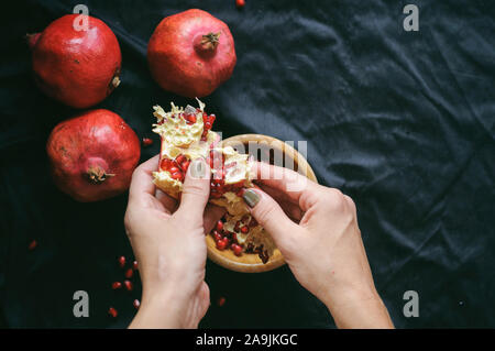 Mädchen reinigt die Frisch rot saftige Granatapfel in der Frame nur weibliche Hände Stockfoto