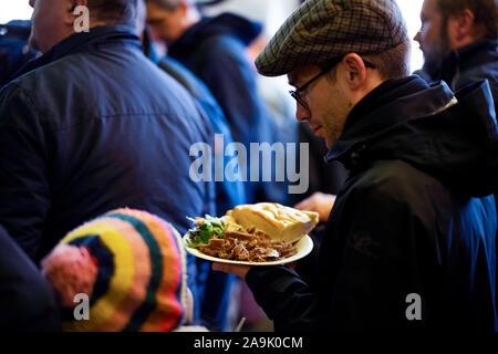 Halle, Deutschland. 16 November 2019, Sachsen-Anhalt, Halle (Saale): Sebastian Striegel (Bündnis 90/Die Grünen, r), Mitglied im Landtag von Sachsen-Anhalt, hält ein Kebab Platte in der Hand an der Snack Bar 'Kiez-Döner' am Tag der Wiedereröffnung. Die Snack Bar, eine der Szenen in der rechten Terroranschlag in Halle (Saale), öffnet offiziell seine Türen. Die Snackbar werden gehören zu den Mitarbeitern, die während des Angriffs gearbeitet. Foto: Alexander Prautzsch/dpa Quelle: dpa Picture alliance/Alamy Leben Nachrichten Quelle: dpa Picture alliance/Alamy leben Nachrichten Stockfoto