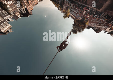 AMSTERDAM, NIEDERLANDE: unbekannter Mann unterhält, neugierigen, führt eine Gratwanderung wandern, auch "funambulism Stockfoto