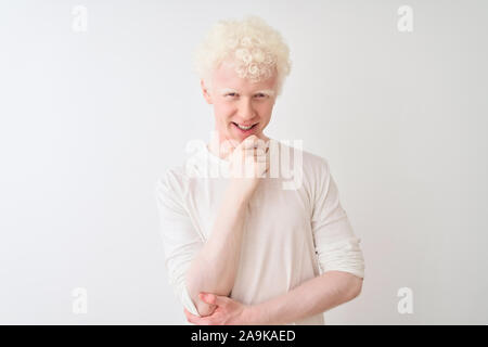 Junge albino blonder Mann legere t-shirt stehend über isoliert weißer Hintergrund mit Blick auf die Kamera sicher lächelnd mit verschränkten Armen und ha Stockfoto