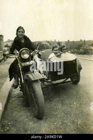 Frauen mit Kindern auf Motorrad mit Seitenwagen, Italien Stockfoto