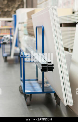 Trolley in einem Hardware-store mit Baumaterial geladen. Reparatur und Konstruktion Konzept. vertikale Foto. Stockfoto