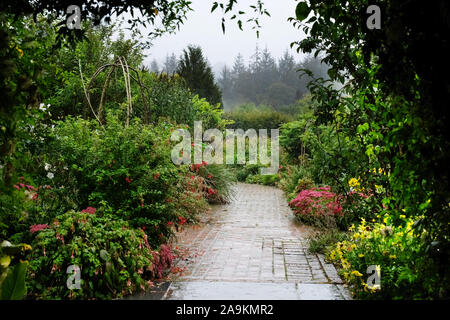 Ein Pfad wickeln Ihren Weg durch ein Englischer Country Garden - Johannes Gollop Stockfoto