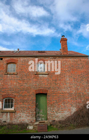 Alte viktorianische Backsteingebäude mit Kamin Windows und grüne Tür Stockfoto