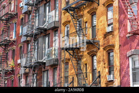 Bunte rote und gelbe Backsteingebäude mit Feuer Treppen an einem sonnigen Tag. Brooklyn. New York City, USA. Stockfoto