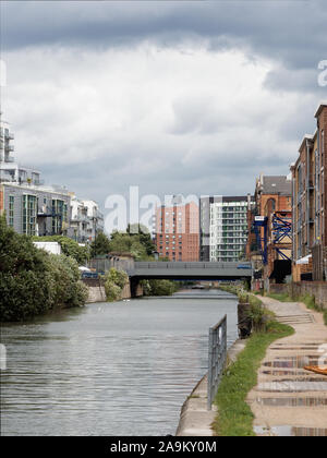 Blick entlang der Limehouse Cut Kanal mit neuen Wohnanlagen in einer post-industriellen Bereich (Limehouse, London, UK). Nach dem Regen. Stockfoto