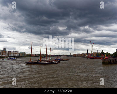 Tideway Lastkähne auf der Themse nähert sich der Super Kanalisation Baustelle in der Nähe von King Edward's Memorial Park in Limehouse. Rotherhithe und Wapping in bg. Stockfoto