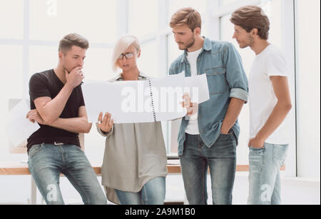 Gruppe von Designern über die Skizzen für ein neues Projekt. Stockfoto