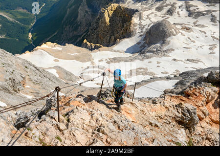 Schöne junge Frau, Bergsteiger, klettern Bergrücken auf der Via ferrata Eisen weg an einem sonnigen Sommertag Stockfoto