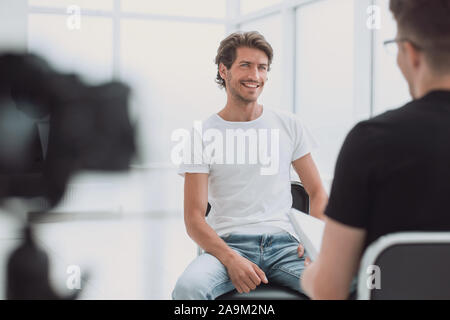 Aus der Nähe. Ein junger Geschäftsmann gibt ein Interview im Büro Stockfoto