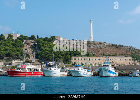 Fischerboote und Ausflugsboote im Hafen mit Treppe und Leuchtturm im Hintergrund - Santa Maria di Leuca in Apulien (Puglia) im südlichen Italien Stockfoto