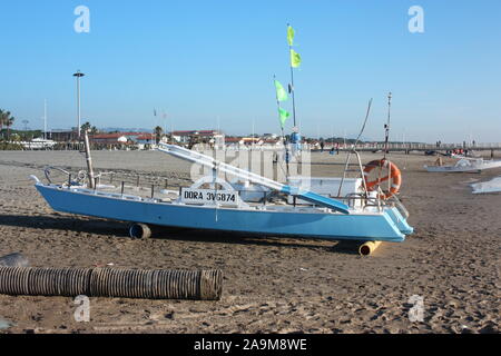 Eine Rettungsinsel. Ein Boot gestrandet am Sandstrand bei Tageslicht in der Versilia, Toskana, Italien geparkt oder Stockfoto