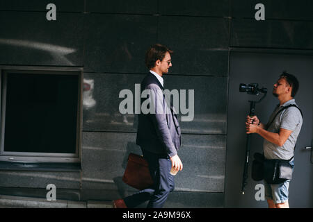 Backstage von Foto- und Videoaufnahmen machen mit einem männlichen Modell Stockfoto