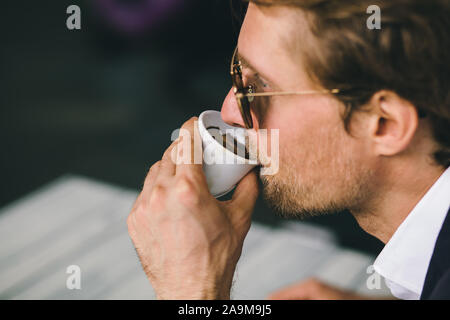 Attraktive Bärtigen jungen Kerl ist Kaffee trinken Closeup Schuß Stockfoto