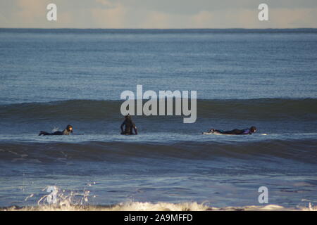 Drei Surfer in der Nordsee Auf einer Winter Abend. Strand von Aberdeen, Schottland, Großbritannien. Stockfoto