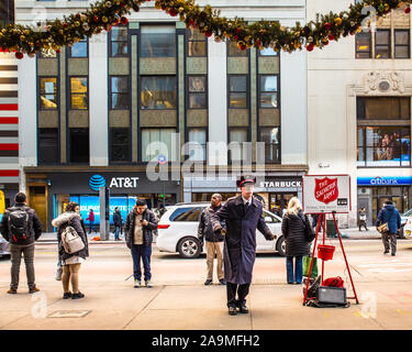 NEW YORK CITY - 7. DEZEMBER 2018: die Heilsarmee Arbeiter Ringe Glocken für Spenden außerhalb der Pennsylvania Station in New York City an Weihnachten Urlaub s Stockfoto