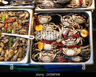 Die koreanische Küche - Ansicht von oben Viele in Sojasauce kleine Krebse in Stahl Fächer eingelegten am lokalen Markt in Seoul City Stockfoto