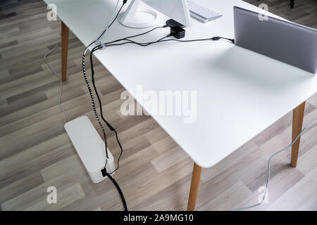 Ansicht von Compute und Laptop auf dem Schreibtisch mit Kabel-Kontrollkästchen Terminplanerdaten über Parkett Stockfoto