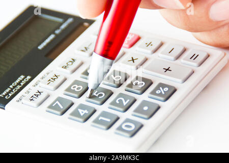 Taschenrechner mit Hand und roten Kugelschreiber close-up Hintergrund Stockfoto