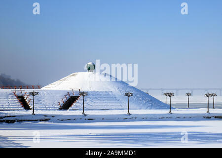 Verschneite Landschaft, Straßen und einer Pyramide im Schnee bedeckt. Stadtbild der Damm in der dnipro Stadt, Dnepropetrovsk, Ukraine, Dezember, Stockfoto