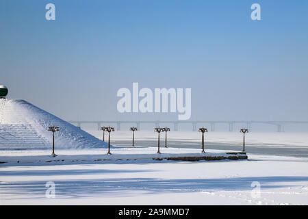 Verschneite Landschaft, Straßen und einer Pyramide im Schnee bedeckt. Stadtbild der Dnipro Stadt, Dnepropetrovsk, Ukraine, Dezember, Januar, Februar Stockfoto