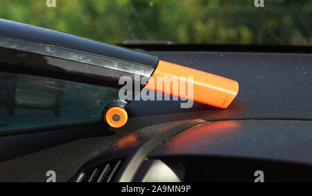 Innenraum gereinigt von Staub mit kleinen orange tragbaren Staubsauger, closeup auf staubigen Armaturenbrett Stockfoto