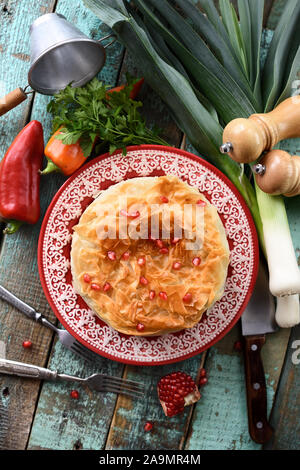 Herzhafte griescreme Gebäck Kuchen mit Gemüse und Granatapfel Samen auf Holz- Hintergrund der Ansicht von oben Stockfoto