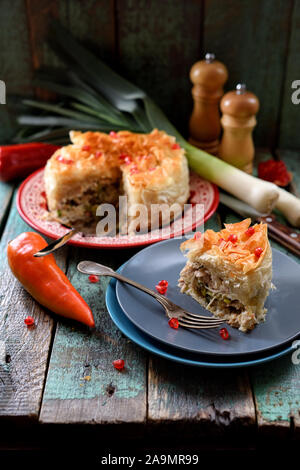 Pikante Blätterteig Torte gefüllt mit Huhn und Gemüse mit Granatapfel Samen auf alten Holzbrettern eingerichteten Raum kopieren Stockfoto