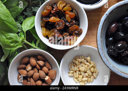 Kräuter, Rosinen, Nüsse, Oliven von oben in kleinen Schalen aus Keramik Stockfoto