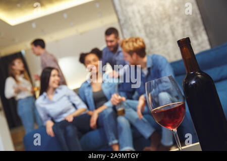 Eine Gruppe von Freunden, die party drinnen Spaß zusammen Wein Flasche und Glas close-up Stockfoto